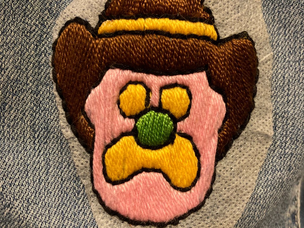 Close-up of a colorful embroidered patch on denim.