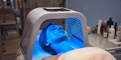 Woman undergoing blue light facial treatment.