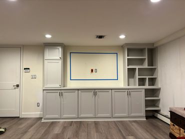 Modern built-in gray cabinets with open shelving in a minimalist room.