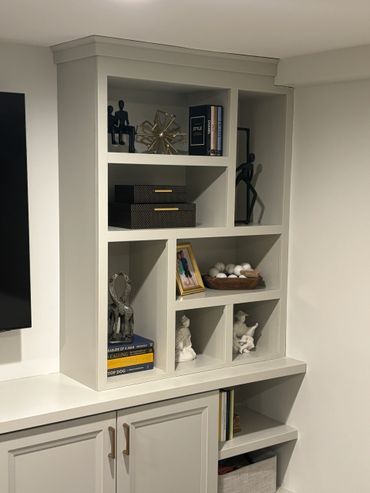 Modern white shelving unit with decorative items and books.