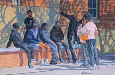 Group of teenagers hanging out near a brick building.
