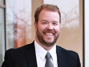 Smiling man in a suit and tie.