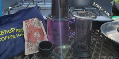 aeropress coffee maker with snow peak titanium mug and hikers brew coffee on picnic table