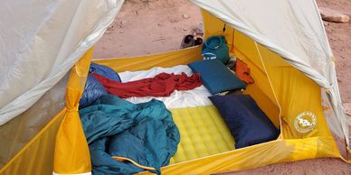 two sleeping pads in a tent by bottomless backpacks
