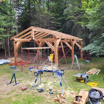 Structure en bois partiellement construite en forêt.