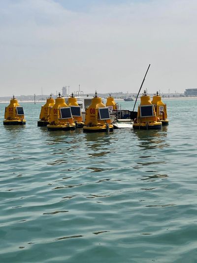Yellow buoys with solar panels floating in water.