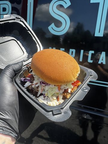 Pulled pork sandwich with coleslaw in a container.