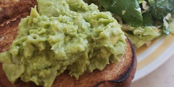 T'SDS Cuisine fresh guacamole over toast, side salad & omelet.