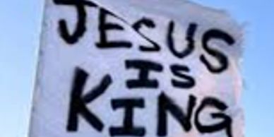 A sign that says "JESUS IS KING" in bold black letters.