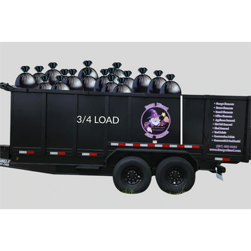 A black dump trailer loaded 3/4 full with garbage bags.