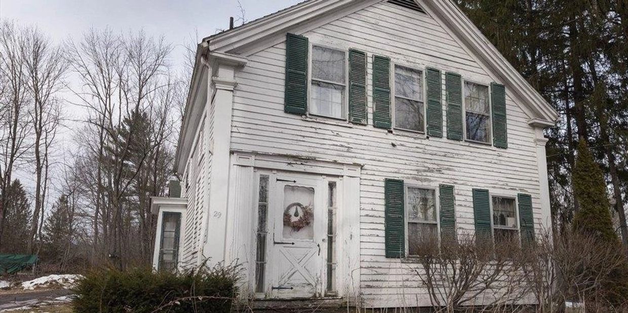White New England style house needing paint and repairs.