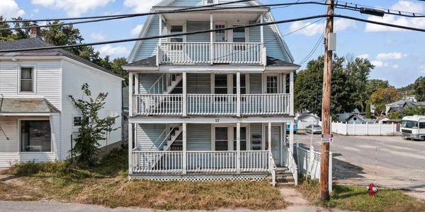 Three-story residential house with multiple balconies and stairs.
