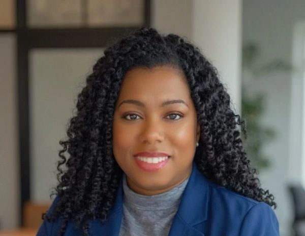 Portrait of a woman with curly hair and a blue blazer.