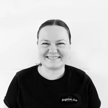 Smiling woman in a black Brightside Deli shirt.