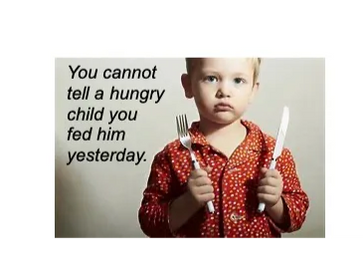 Picture of a young boy looking sad, holding a knife in one hand, a fork in the other. To his left it