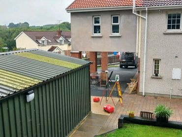 Surveying equipment set up outside houses in a residential neighborhood.