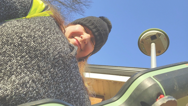 Woman in winter clothing smiling outdoors under clear blue sky.