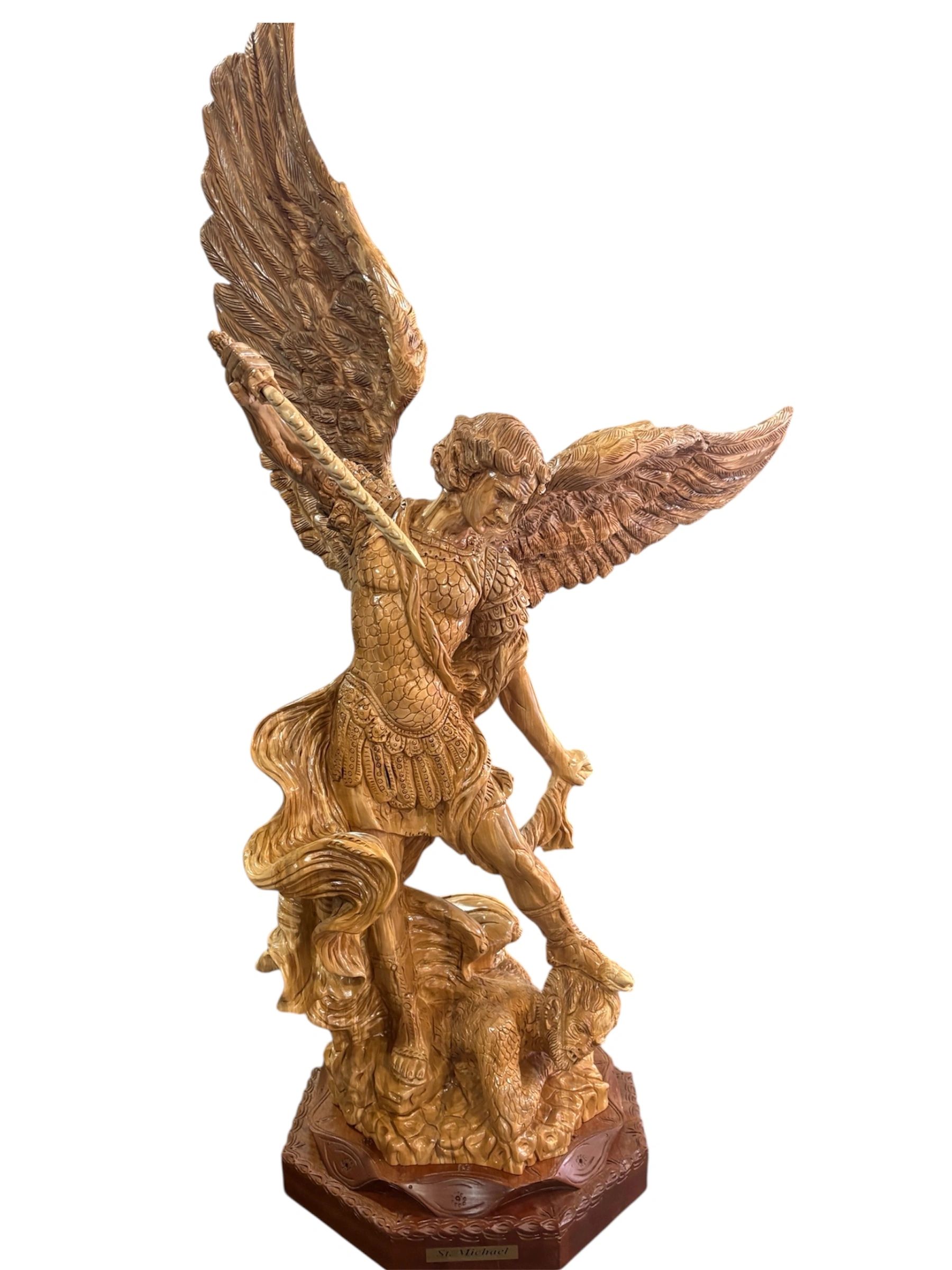 Intricately carved wooden statue of St. Michael defeating a demon.