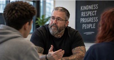 Man attentively talking to two people.