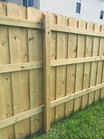 New wooden fence with fresh green grass beside it.