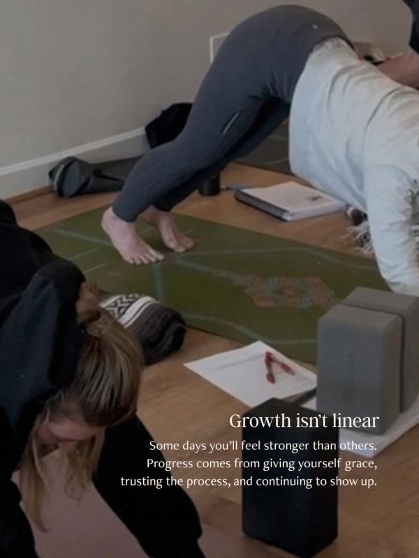 Two people doing yoga indoors with a motivational growth quote.