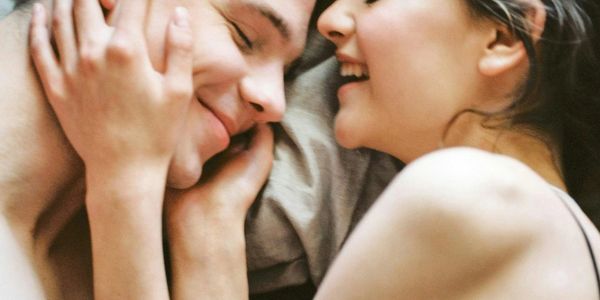 Man and woman in bed looking playful and intimate