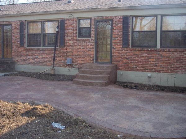 Brick house exterior with concrete steps and patio.