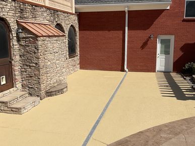 Sunlit backyard patio with stone and brick walls.