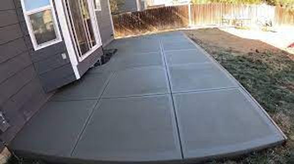 Freshly poured concrete patio outside a house.