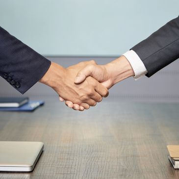 Business handshake over a desk.