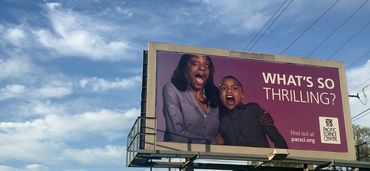 Billboard featuring an ad for Pacific Science Center. Image of mom and child gasping. 