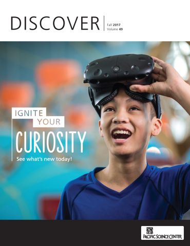 Cover of a newsletter, image of a kid holding virtual reality glasses and smiling. 