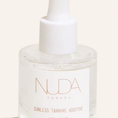 Clear glass bottle of NUDA Canada sunless tanning additive with white dropper cap.