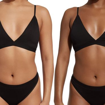 Two women wearing black bralettes and matching black bottoms, showcasing different skin tones.