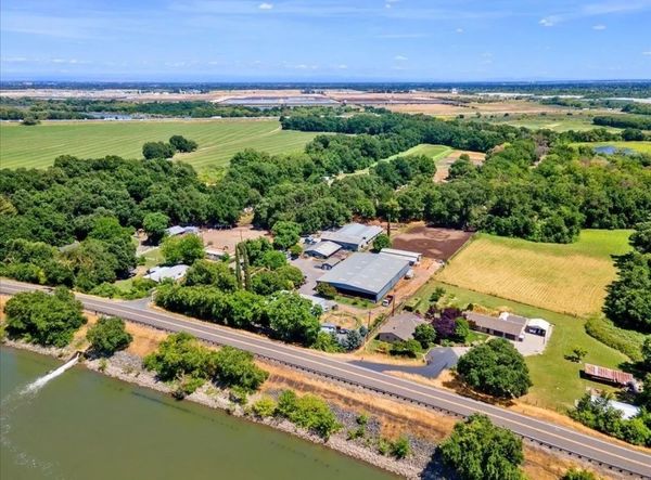 Aerial view of a rural farmstead surrounded by greenery and fields.