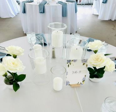 Elegant wedding table setup with white roses and candles.