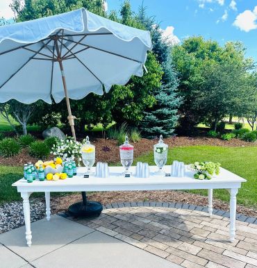 Refreshing outdoor drink station under an umbrella.