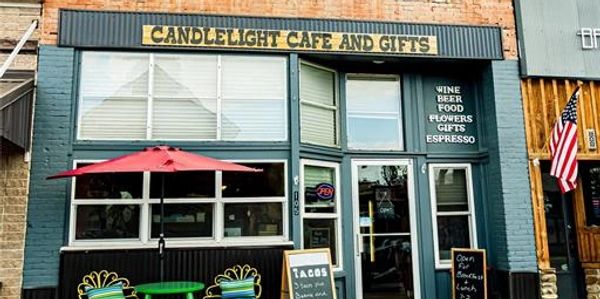 Front view of Candlelight Cafe and Gifts with outdoor seating and menu boards.