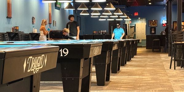 A row of 8-foot pool tables at the pool hall.