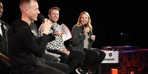 People sitting and talking on stage with microphones.