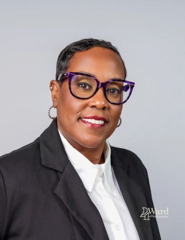 Professional portrait of a woman wearing glasses and a black blazer.