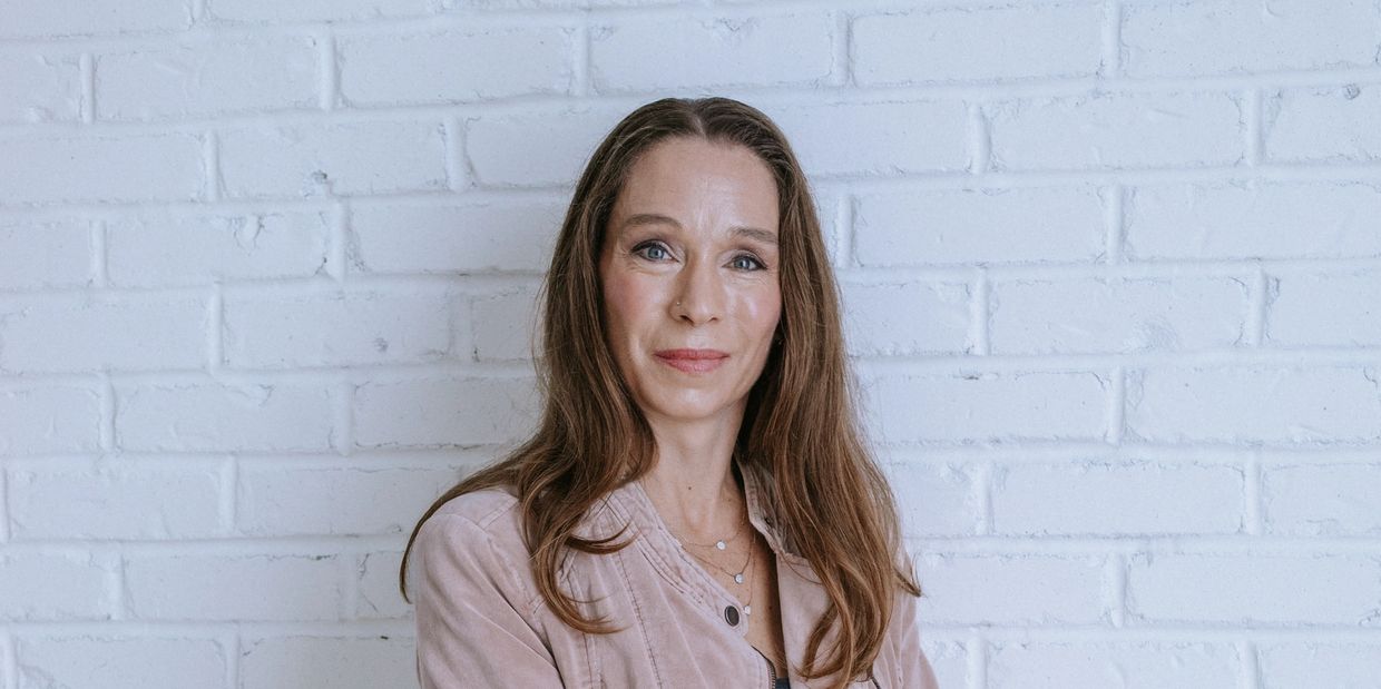 RJ Adler, founder of Adler Accounting Advisory, standing against a white brick wall.