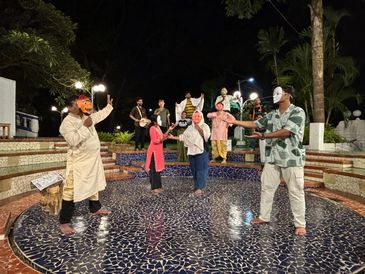 A group wearing masks performing outdoors at night.