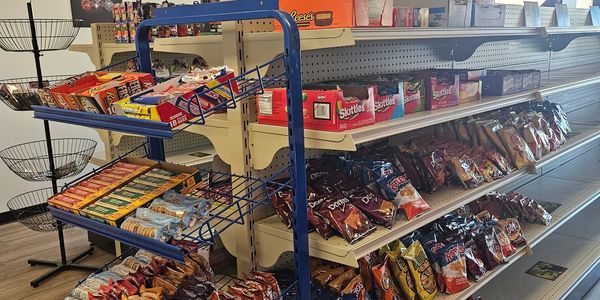 Snack aisle in a store with chips, candy bars, and cookies.
