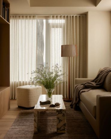 Minimalist living room with beige tones and natural light.