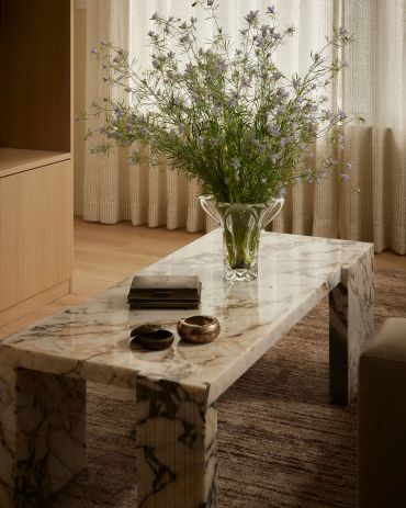 Marble table with flowers and decorative items.