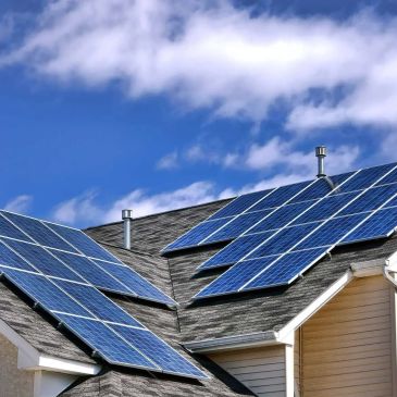 Solar panels installed on a residential roof under a blue sky.