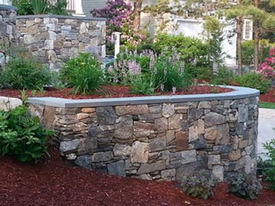 Backyard landscape with retaining wall and garden features.