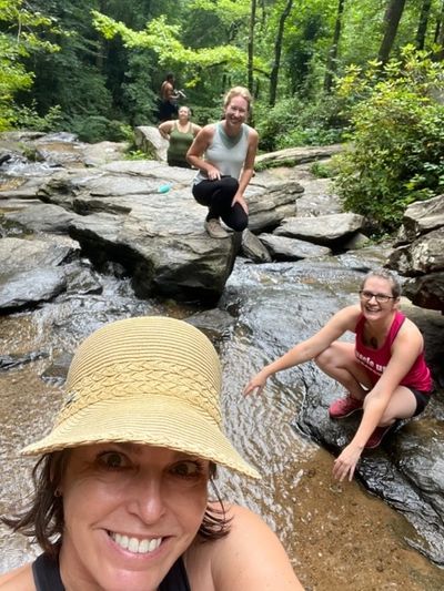 group of 5 people posing for a selfies at a creek 