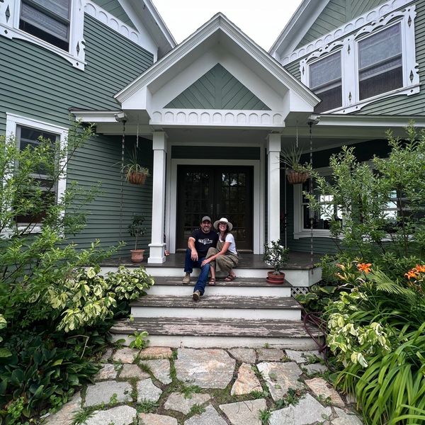 Farm owners sitting on the front steps of the farm house. 